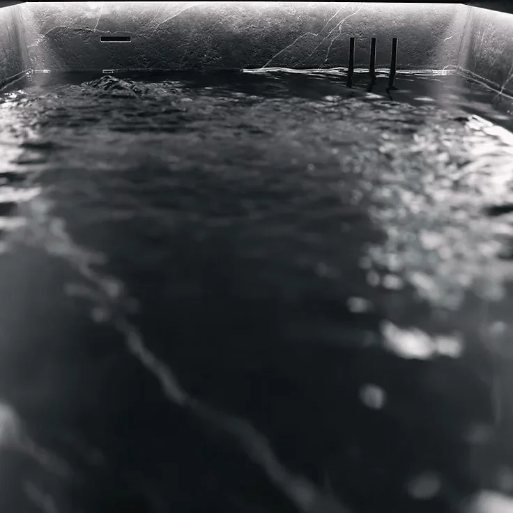 Água em movimento numa banheira de imersão em Calacatta Black da Nordic Vitality