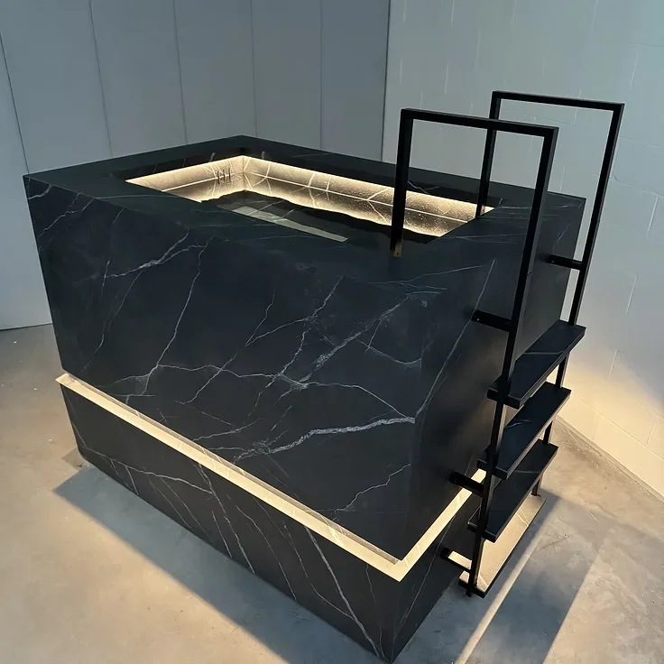 Banheira de imersão Nordic Vitality em mármore preto, com escada em metal e iluminação LED