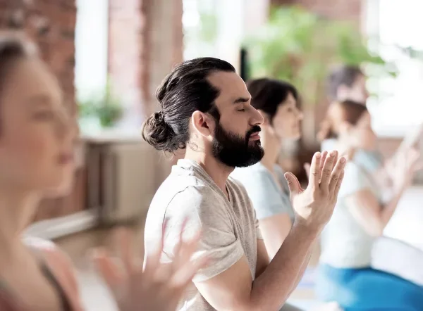 Grupo a meditar de olhos fechados, o bem-estar mental como benefício do banho japonês