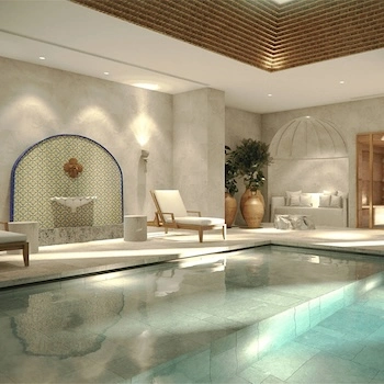 Piscina interior de spa com espreguiçadeiras, fonte azulejada e área de repouso